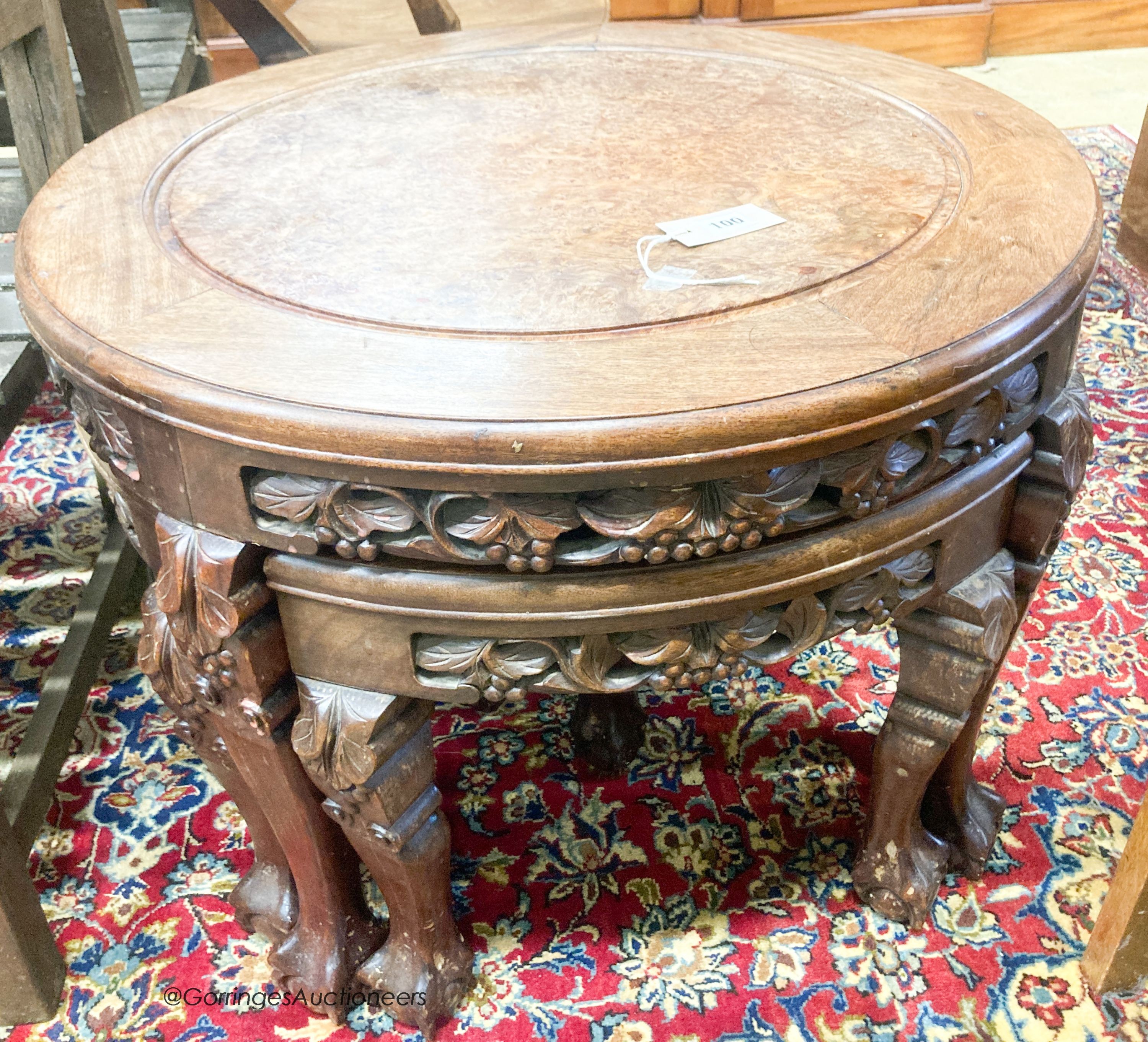 A Chinese circular carved hardwood circular low table with a burr wood centre panel and companion nest of four tables with claw feet, diameter 70cm, height 51cm